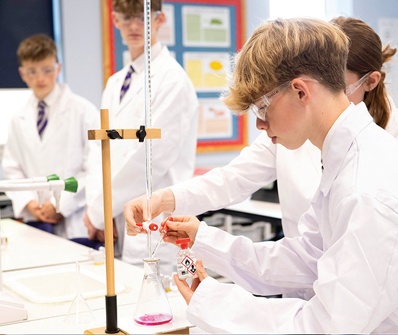 Students in science class wearing lab coats.